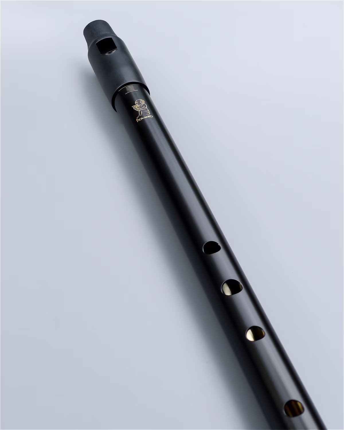 Close-up of the Howard Classic Low D whistle in Black finish showing the precision-machined finger holes and handcrafted finish.