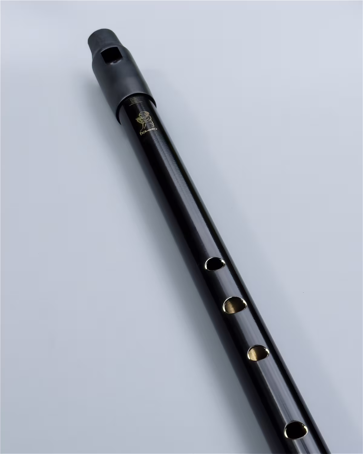 Close-up of the Howard Classic Low D whistle in Black Silk finish showing the precision-machined finger holes and low-reflective Black Silk finish detail