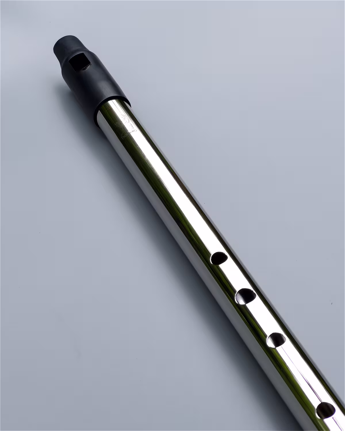 Close-up of the Howard Classic Low D whistle in nickel finish showing the precision-machined finger holes and polished surface.